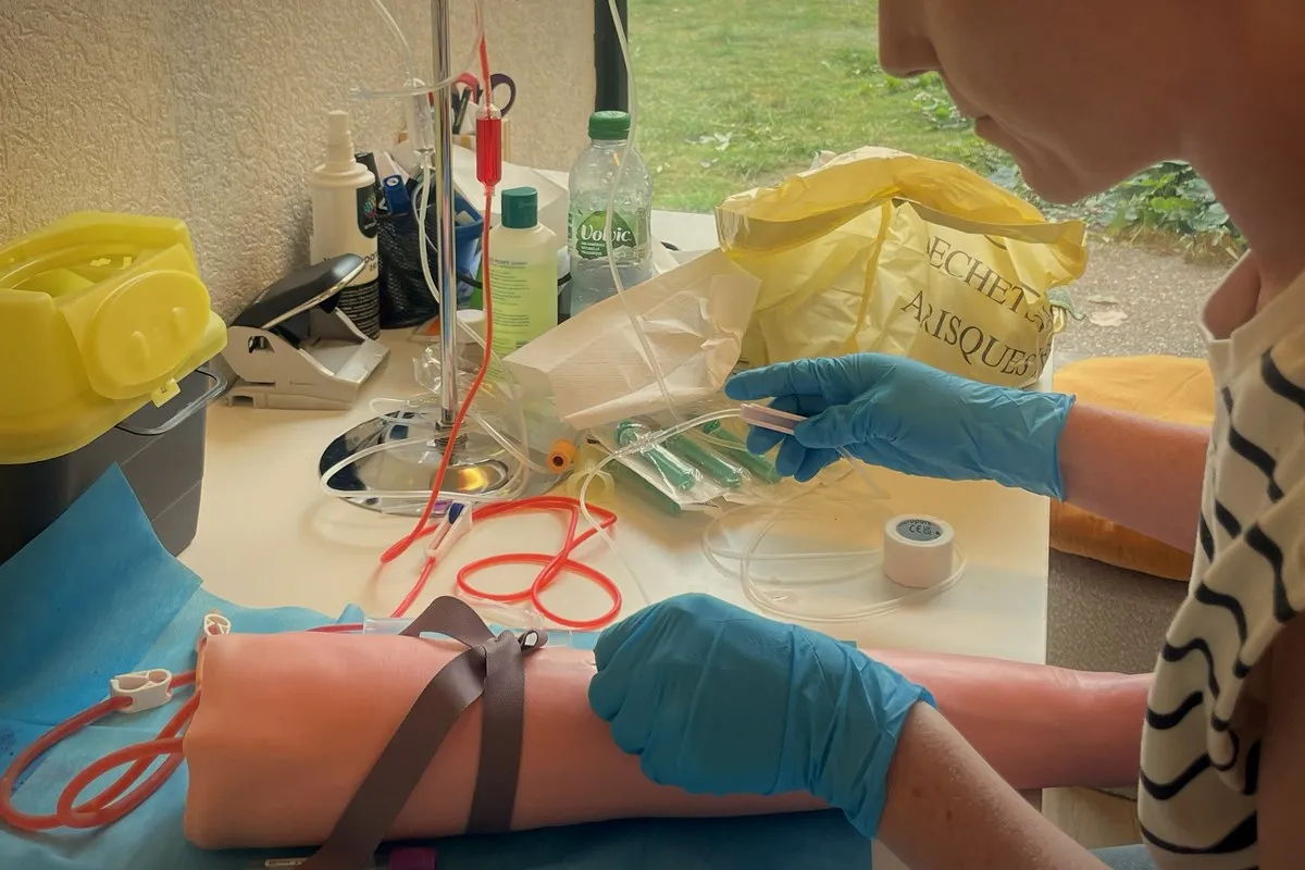 Formation prise de sang à Genève · prélèvement veineux avec main gantée et garrot, en cabinet